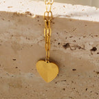 Mini Paper Clip Chain Anchoring a Patterned Heart Charm in Gold