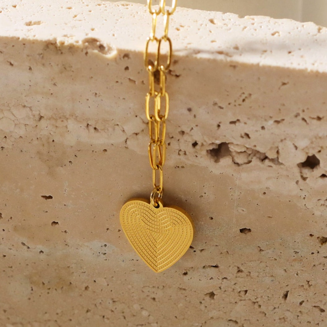 Mini Paper Clip Chain Anchoring a Patterned Heart Charm in Gold