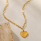 Mini Paper Clip Chain Anchoring a Patterned Heart Charm in Gold